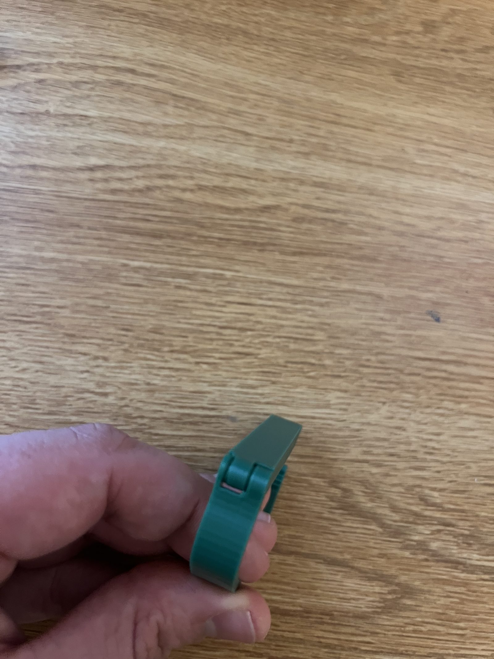 Final capo prototype held in hand with a working hinge